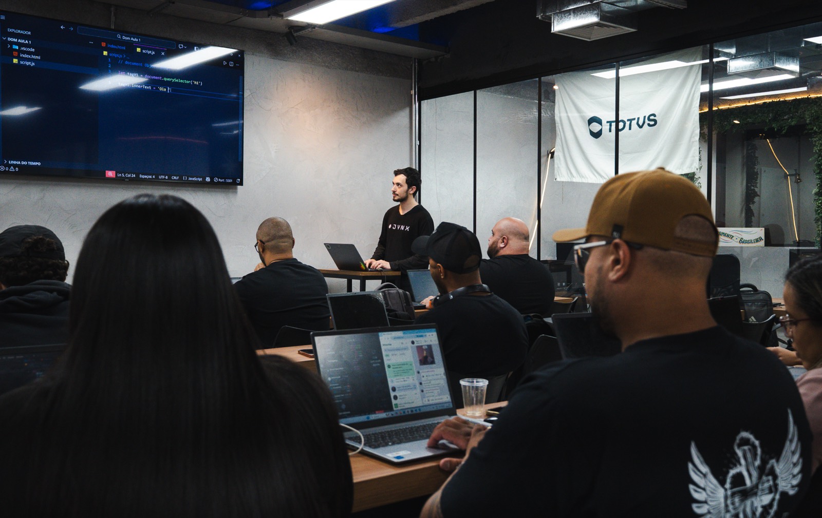 Turma em treinamento presencial da JYNX, participantes com notebooks em sala